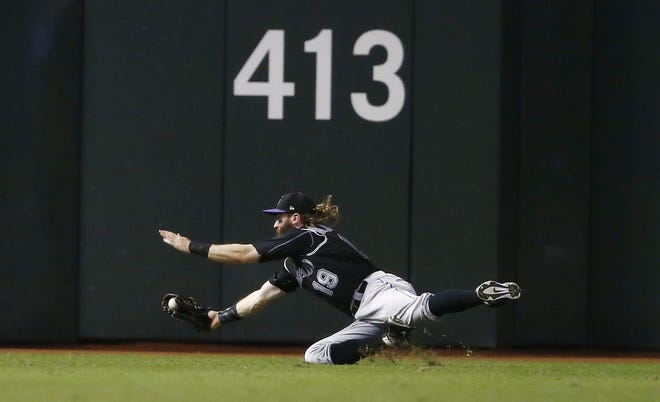 Colorado Rockies' Charlie Blackmon dives for a line drive hit by Arizona Diamondbacks' Chris Iannetta but the ball would pop out of Blackmon's glove and Iannetta would get a double on the play during the first inning of a baseball game Thursday, Sept. 14, 2017, in Phoenix. (AP Photo/Ross D. Franklin)