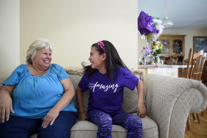 Maureen Cleary, left, shares a laugh with her adopted daughter, Vanessa, who was living in an orphanage when Maureen adopted her at less than 1 year old. Vanessa, now a student at Enfield High School, has won the Connecticut and Miss Amazing pageants for people with disabilities. [HARTFORD COURANT]