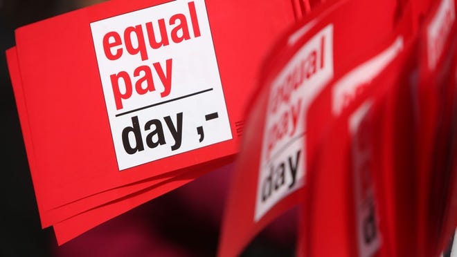 BERLIN, GERMANY - MARCH 21: Flags reading 'Equal Pay Day' are seen during the 'Equal Pay Day' demonstration on March 21, 2014 in Berlin, Germany. The annual event recognizes the wage gap between the sexes in the country, where women's salaries still lag behind that of men, particularly in the states that were once East Germany. (Photo by Adam Berry/Getty Images)