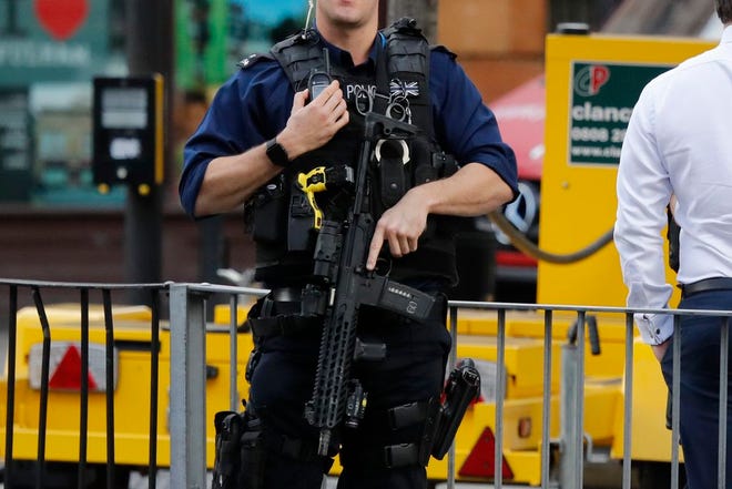 An armed police officer stands nearby after an incident on a tube train at Parsons Green subway station in London, Friday. A reported explosion at the train station sent commuters stampeding in panic, injuring several people on Friday at the height of London's morning rush hour, and police said they were investigating it as a terrorist attack.