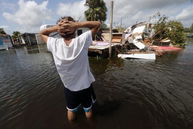Larry Dimas walk around his destroyed trailer in Immokalee. Irma badly damaged Dimas' mobile home and destroyed another he used for rental income, making his tough life even harder. [Gerald Herbert / AP]