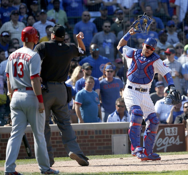 Chicago Cubs catcher Willson Contreras, right, slams his mask down as home plate umpire Jordan Baker tosses him out of the game while St. Louis Cardinals' Matt Carpenter watches during the fifth inning of Friday's game in Chicago. (AP Photo/Charles Rex Arbogast)