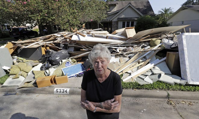 AP PHOTO/DAVID J PHILLIP Houston resdient Arlene Estle stands outside her home damaged by floodwaters from Hurricane Harvey. Insuerers anticipate about $19 billion in insurance claims for damaged cars and buldings due to the storm.