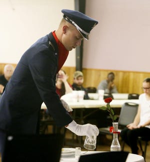 David Rice, a University of Alabama Air Force cadet, places a glass upside down as the table is set Friday during the setting of the Missing Man Table as part of the POW-MIA Recognition Day ceremony at the Veterans of Foreign Wars Post 6022. The ceremony honored prisoners of war and troops who are missing in action.  [Staff Photo/Erin Nelson]