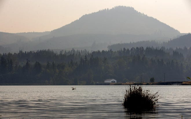 The Lowell Covered Bridge stands out among the smoky hillside near Dexter Reservoir in Lowell on Friday. Smoke is expected to hang around the south Willamette Valley on Saturday before winds clear it out late Sunday. (Andy Nelson/The Register-Guard)