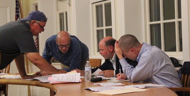 Robert Berube of ProLine Engineering looks over plans with Zoning Board of Appeals members Paul Treloar, Paul Grillo and Michael Backus during the meeting last Thursday evening. PHOTO BY BILL HALL/THE SPECTATOR/SCMG