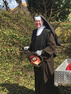 Sister Margaret Ann holds a chain saw near Miami. Police said she was cutting trees to clear the roadways around Archbishop Coleman Carrol High School in the aftermath of Hurricane Irma. [MIAMI-DADE POLICE DEPARTMENT]