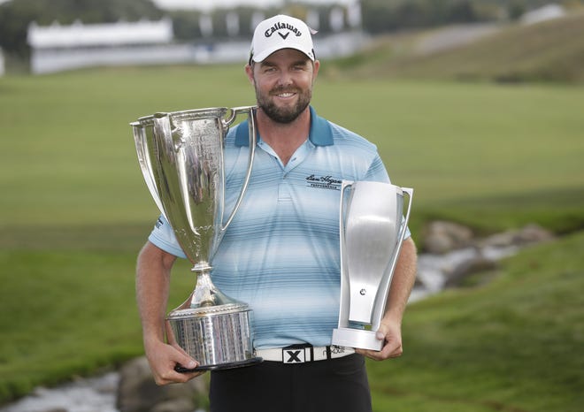 Marc Leishman smiles as he poses with the Wadley Cup, left, and the BMW Championship trophy after winning the BMW Championship golf tournament at Conway Farms Golf Club, Sunday, Sept. 17, 2017, in Lake Forest, Ill. (AP Photo/Charles Rex Arbogast)