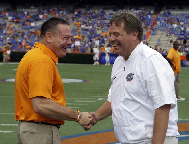 Butch Jones (left) and Jim McElwain, yes, before last Saturday's game. Both coaches have learned to dodge the arrows. [ASSOCIATED PRESS/JOHN RAOUX]