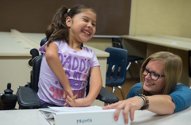 Krista Burton, right, shares a laugh with fourth grader Natalie Quintana, 9, who is a student at French Elementary as they work with the a customized pencil grip for Natalie in Colorado Springs, Colo. [DOUGAL BROWNLIE/COLORADO SPRINGS GAZETTE]