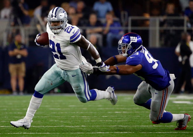 Dallas Cowboys running back Ezekiel Elliott (21) escapes a tackle attempt by New York Giants linebacker B.J. Goodson (93) in the second half of an NFL football game, Sunday, Sept. 10, 2017, in Arlington, Texas.