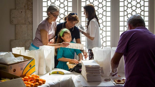 (l to r) Yael Hershfield, Palm Beach Gardens, and her daughter, Ariella, 11, Esta Jacobson, Palm Beach, Aracelli Shabbot, Palm Beach and Paul Darrow, West Palm Beach prepare lunch bags for victims of Hurricane Irma at Palm Beach Synagogue in Palm Beach, Florida on September 17, 2017. Two hundred meals were made with each bag containing a peanut butter and jelly sandwich, chips, fruit, candy, a bottle of water and a scratch off lottery ticket. Rabbi Moshe Scheiner said the synagogue wanted to help the down and out and provide a little hope and optimism. (Allen Eyestone / Daily News)