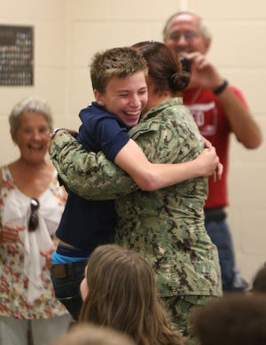 Petty Officer 3rd Class Chasmine Banks lifts her son, Gabriel Little, as they hug Monday at Mowat Middle School in Lynn Haven. [PATTI BLAKE/THE NEWS HERALD]