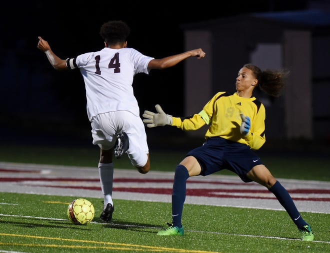 Ambridge's Christian Fisher (14) gets past Hopewell goalkeeper A.J. Walker (99) before scoring his 50th career goal during Ambridge's game against Hopewell on Tuesday at Ambridge Area High School.