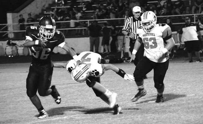 Hominy running back Kaden Sutton (36) attempts a stiff arm against Pawhuska defender J.T. Waddle (7) Friday night in Hominy. Waddle fought through the stiff arm to trip up Sutton. Chris Day/Journal-Capital