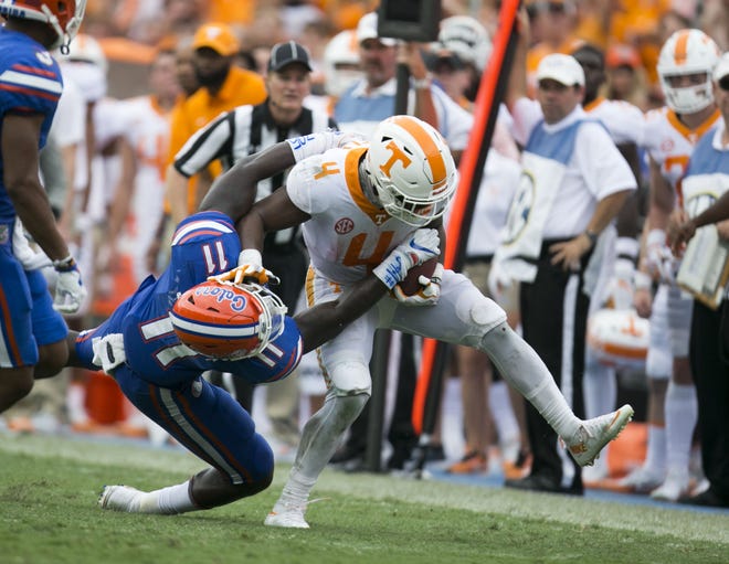 Florida linebacker Vosean Joseph tries to bring town Tennessee running back John Kelly during Saturday's game at Ben Hill Griffin Stadium. [Alan Youngblood/Staff photographer]