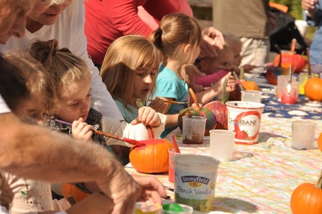 Children paint pumpkins at a past Stony Brook fall fair. This year's event is set for Oct. 7 at the wildlife sanctuary in Norfolk. [COURTESY PHOTO]