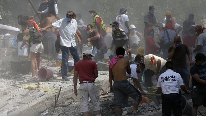Voluntarios ayudan en un edificio derrumbado en la colonia Roma de la Ciudad de México. (AP Photo/Eduardo Verdugo)