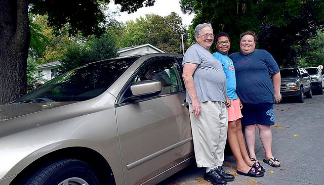 Front left, Blanche, Catherine and Stephanie Zearing stand next to their new car. Stephanie, a home health nurse for the elderly, received the car through the United Way’s Wheels for Work program. Photo by Dan Mika/Ames Tribune