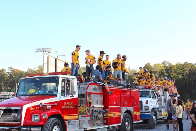 St. Amant football players parade on fire trucks at the 2017 homecoming pep rally.