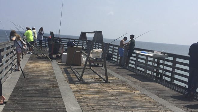 A group of fishermen gather Wednesday afternoon at Lake Worth Pier after the city reopened it at noon. (Kevin D. Thompson/The Palm Beach Post)
