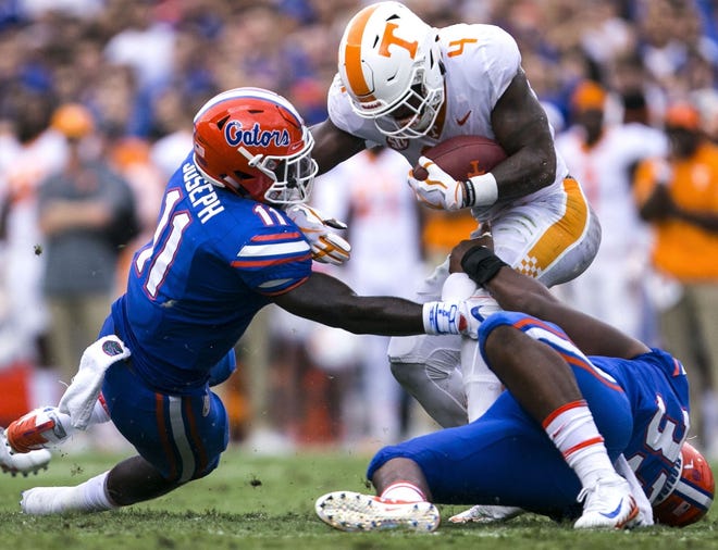 Tennessee running back John Kelly tries to get away from Florida linebacker Vosean Joseph last Saturday at Ben Hill Griffin Stadium. Kelly rushed for 141 yards and a touchdown on 19 carries. [GATEHOUSE MEDIA SERVICES/CYNDI CHAMBERS]