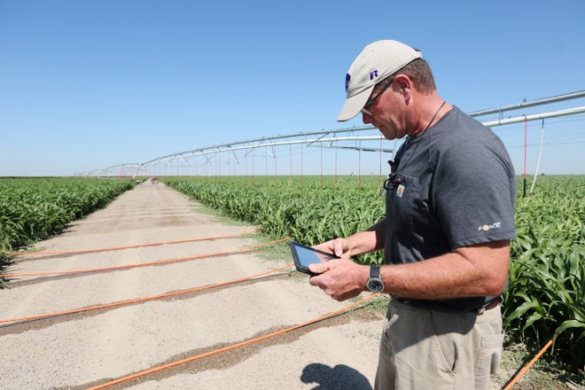 Dwane Roth uses a tablet to control the irrigation center pivot as well as to monitor water measurements at the Water Technology Farm on Tuesday, July 25, 2017, in Finney County. [Lindsey Bauman/HutchNews]