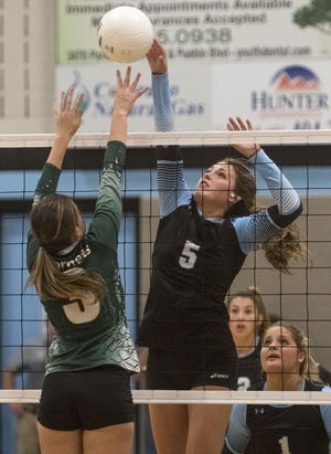 Pueblo West High School's Olivia Sherman (5) taps the ball over the outstretched hands of Pueblo County High School's Sophia Valentine as Brilane Manchego (1) and Reagan Emery look on during the first game of their match at West High School Thursday night September 21, 2017 in Pueblo West, Colo. West went on to beat County 26-24, 26-24, 25-8. (Bryan Kelsen, The Pueblo Chieftain)