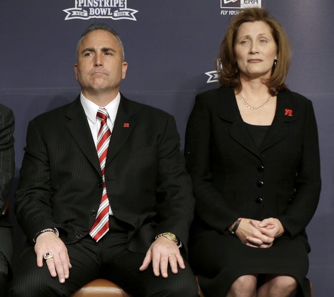 FILE - In this Dec. 10, 2013, file photo, Rutgers athletic director Julie Hermann, right, and head football coach Kyle Flood, listen during an NCAA college football news conference in New York. The NCAA on Friday, Sept. 22, 2017, has placed Rutgers on two-year probation and publically reprimanded and censured the university for failing to monitor its football program over a five-year period between 2011 and 2015. The NCAA says Rutgers helped itself by cooperating with investigation, firing Flood and Hermann after the 2015 season, and implementing a new drug testing and hiring a new chief medical officer. (AP Photo/Seth Wenig, File)