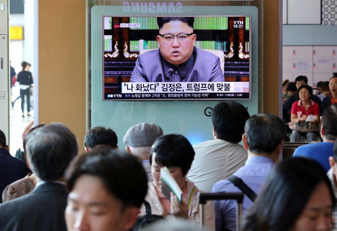 People watch a TV screen showing an image of North Korean leader Kim Jong Un delivering a statement in response to U.S. President Donald Trump's speech to the United Nations, in Pyongyang, North Korea, at the Seoul Railway Station in Seoul, South Korea, Friday, Sept. 22, 2017. Kim, in an extraordinary and direct rebuke, called U.S. President Donald Trump "deranged" and said he will "pay dearly" for his threats, a possible indication of more powerful weapons tests on the horizon.The signs read "I was angry." (AP Photo/Ahn Young-joon)