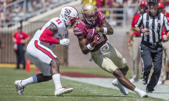 Florida State wide receiver Auden Tate closes his eyes before being hit by North Carolina State defender Jarius Morehead in the first half of an NCAA college football game in Tallahassee on Saturday. [MARK WALLHEISER / ASSOCIATED PRESS]