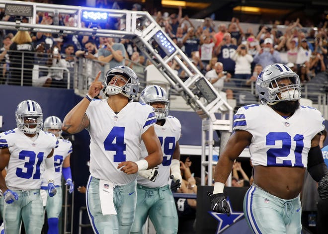 Dallas Cowboys' Dak Prescott (4) and Ezekiel Elliott (21) lead the team onto the field on Aug. 26 in Arlington, Texas. Prescott and Elliott never really had a humbling "welcome to the NFL" moment together as rookies. It finally came in their 18th game. The question now is how the star Cowboys respond. [AP Photo / Roger Steinman, File]