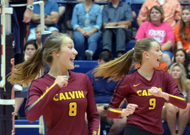Calvin College's Sydney Segard, left, and Jenna Lodewyk celebrate during a volleyball match against Hope College on Saturday at DeVos Fieldhouse. [Dan D'Addona/Sentinel staff]