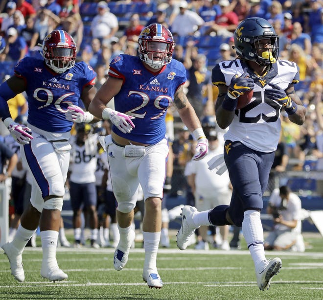 West Virginia running back Justin Crawford (25) is chased into the end zone by Kansas defensive tackle Daniel Wise (96) and linebacker Joe Dineen Jr. (29) to score a touchdown during the first half of an NCAA college football game Saturday, Sept. 23, 2017, in Lawrence, Kan. [Charlie Riedel/Associated]