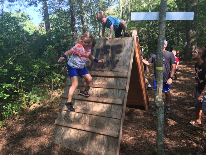 Finley Hamilton, 8, descends from a wooden wall obstacle at the Tuff Buddy mud course Sunday in Griswold. [Ryan Blessing/ NorwichBulletin.com]