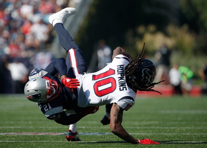 Texans receiver DeAndre Hopkins catches a pass for short yardage as Patriots cornerback Malcolm Butler makes the tackle on Sunday.
