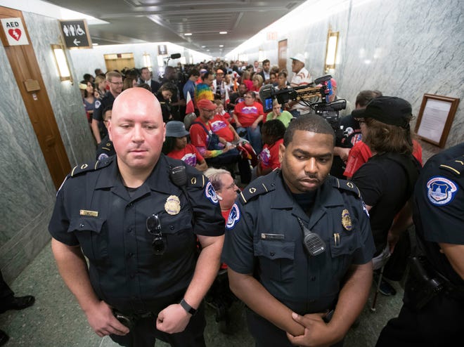 U.S. Capitol Police maintain order as hundreds of people, many with disabilities, arrive for a Senate Finance Committee hearing on the last-ditch GOP push to overhaul the nation's health care system, on Capitol Hill in Washington, Monday, Sept. 25, 2017. (AP Photo/J. Scott Applewhite)