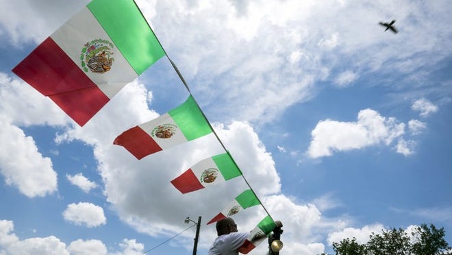 Austin is entering into a “science city network” agreement with Monterrey, Mexico, as the two cities look to promote business and economic opportunities across the border. An Austin volunteer is shown in this 2015 photo hanging a plastic streamer of Mexican flags for a Cinco de Mayo event.