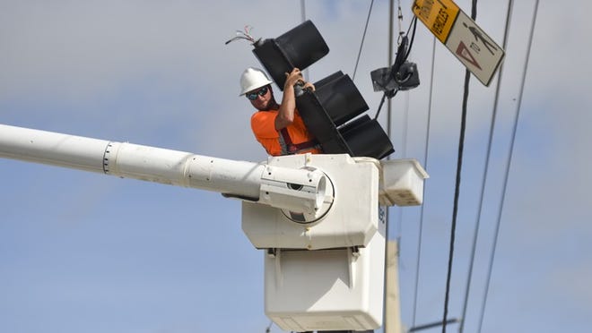 Brian Mark, 27, of Palm Beach County’s Traffic Division, rides a lift to access a traffic light at the intersection of U.S. 1 and Marcinski Road in Jupiter on Monday, Sept. 11, 2017, the day after Hurricane Irma affected Palm Beach County in Florida. Mark said the department was working to fix as many lights as it could get to. (Andres Leiva / The Palm Beach Post)