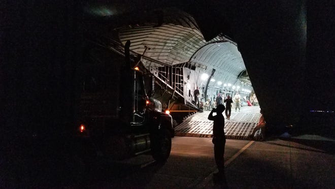 Airmen direct a semi truck carrying a large generator onto a C-5 cargo plane at Fort Bragg’s Pope Field on Wednesday. [Drew Brooks/The Fayetteville Observer]