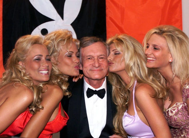 FILE - In this May 14, 1999 file photo, Playboy founder and editor in chief Hugh Hefner receives kisses from Playboy playmates during the 52nd Cannes Film Festival in Cannes, France. Hefner has died at age 91. The magazine released a statement saying Hefner died at his home in Los Angeles of natural causes on Wednesday night, Sept. 27, 2017, surrounded by family. (AP Photo/Laurent Rebours, File)