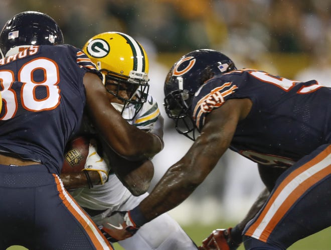 Green Bay Packers' Davante Adams is hit by Chicago Bears' Adrian Amos and Danny Trevathan during the second half Thursday. The Bears were penalized on the play and Adams was taken off the field on a stretcher. (AP Photo/Matt Ludtke)