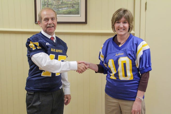 Waynesboro Area School District Superintendent Dr. Tod Kline and Greencastle-Antrim School District Superintendent Dr. Kendra Trail shake hands while wearing the other school's football jersey on Wednesday morning at the Clayton Avenue administrative office in Waynesboro as they bet on the Oct. 20 football game.