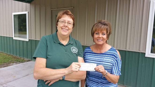Karen Russell, left, president of the Henry County Humane
Society - Geneseo, accepts an $80,000 donation from Brenda Lotridge, president of the Jackson Foundation.