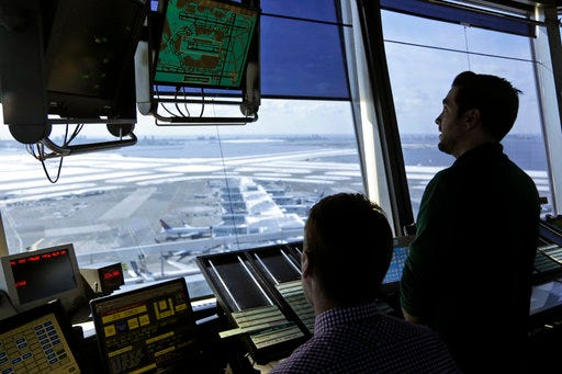 In this March 16, 2017 photo, air traffic controllers work in the tower at John F. Kennedy International Airport in New York. The Senate has passed a bill that would avoid a partial shutdown of federal aviation programs and provide tax relief for hurricane victims. (AP Photo/Seth Wenig)