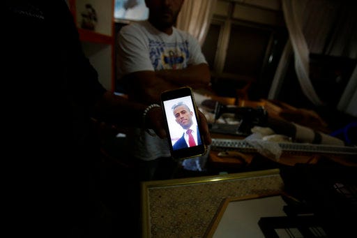 FILE - In this Tuesday, Sept. 26, 2017 file photo, a relative shows a photo of Nimr Jamal who opened fire at the entrance of a settlement Tuesday killing three people, at his family's home in the West Bank village of Beit Surik. An Israeli Shin Bet security service investigation revealed that the 37-year-old Jamal was a troubled man with a history of domestic violence, whose wife had recently fled to Jordan to escape his abuse, leaving him behind with their four children. According to this account, Jamal snapped, but instead of killing himself or his relatives in anonymity he decided to go out in a blaze of glory amid the maelstrom that is the Israeli-Palestinian conflict. (AP Photo/Nasser Shiyoukhi, File)