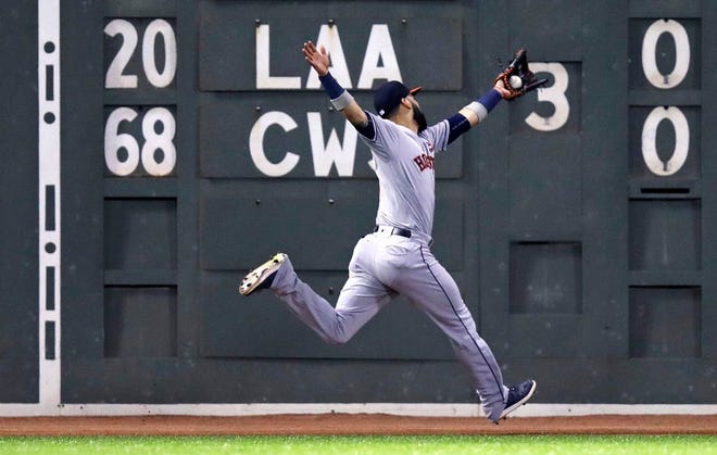 Houston Astros left fielder Marwin Gonzalez stretches to make the catch on a deep drive to the warning track by Boston Red Sox's Rafael Devers during the fourth inningat Fenway Park in Boston, Thursday, Sept. 28, 2017.