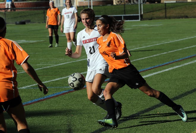 Woburn sophomore Ashlyn Pacheco races along the sidelines with Winchester's Anna Carazza in the first half of their game Thursday afternoon, Sept. 28, 2017. [Wicked Local Staff Photo/Ann Ringwood]