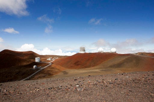 FILE - This Aug. 31, 2015, file photo shows telescopes on the summit of Mauna Kea on Hawaii's Big Island. Hawaii's land board on Thursday, Sept. 28, 2017, granted a construction permit for a giant telescope on a mountain that Native Hawaiians consider sacred, a project that has divided the state. The $1.4 billion Thirty Meter Telescope has pitted people who say the instrument will provide educational and economic opportunities against those who say it will desecrate the state's tallest mountain, called Mauna Kea. (AP Photo/Caleb Jones, File)