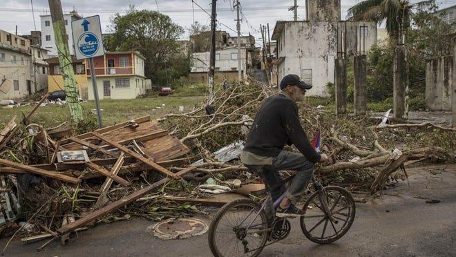 Juan Perez rides though a neighborhood in Arecibo, Puerto Rico, that was flooded by Hurricane Maria, Sept. 23, 2017. Hurricane Maria lashed Puerto Rico as a strong Category 4 storm, causing widespread damage and leaving the island without power. (Victor J. Blue/The New York Times)